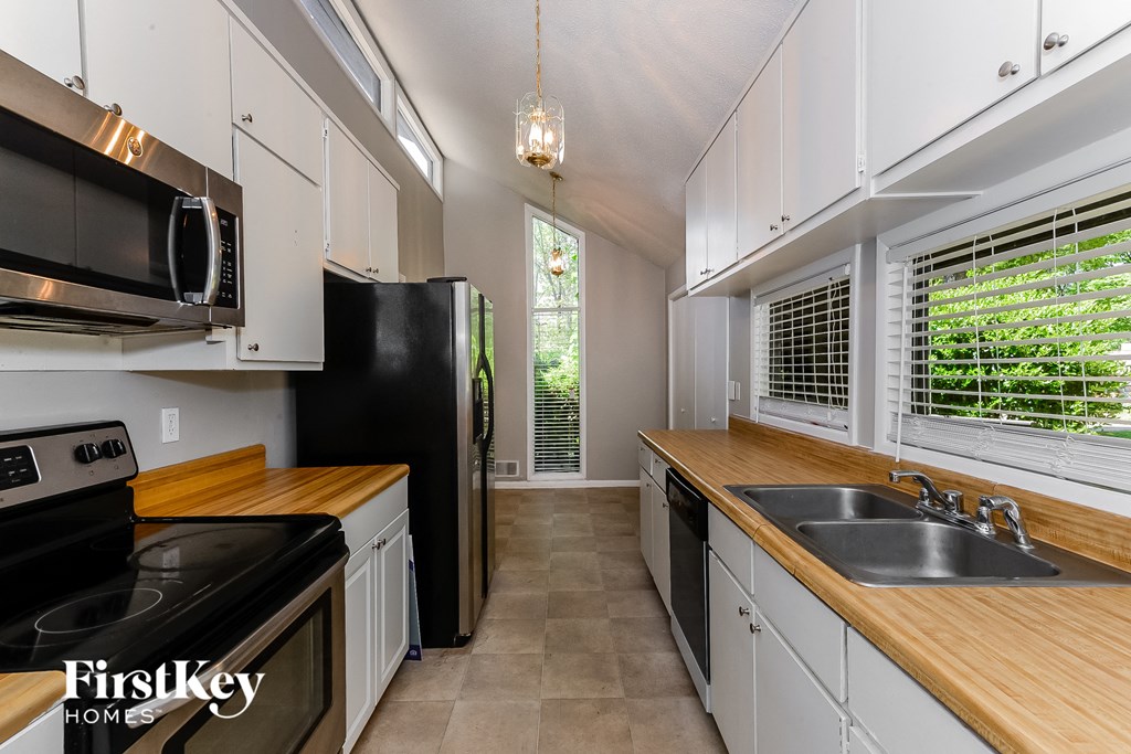 a kitchen with white cabinets and black appliances and a sink