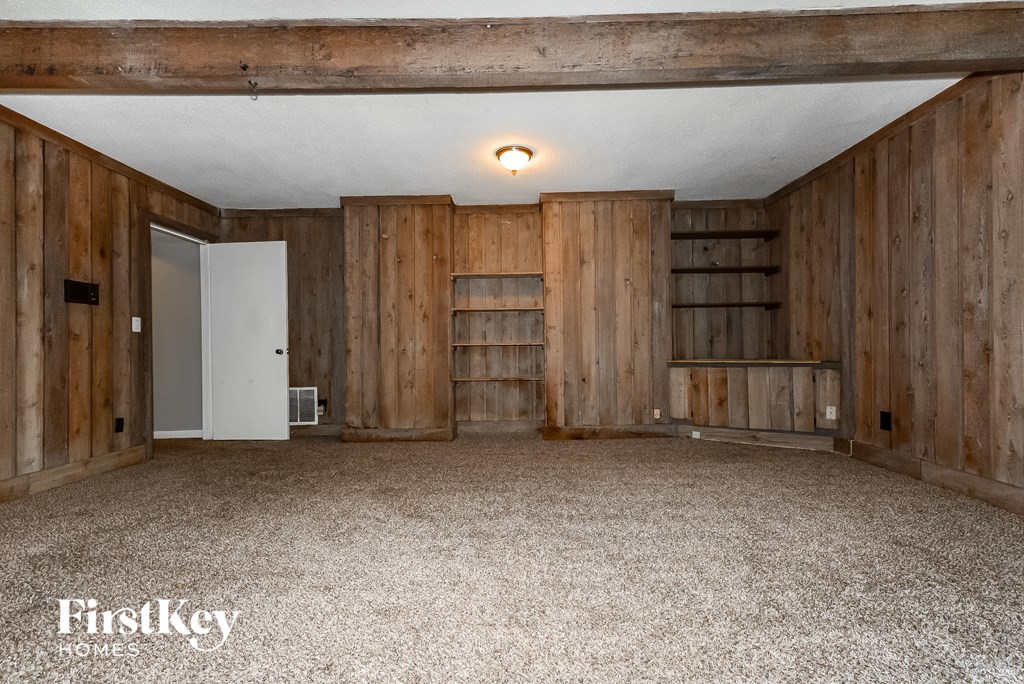 a bedroom with wood walls and a carpeted floor