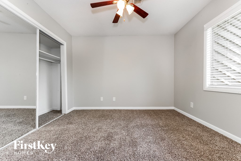 the bedroom has a closet and a ceiling fan