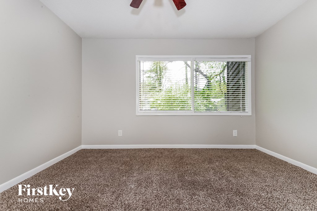 a empty room with carpet and a window