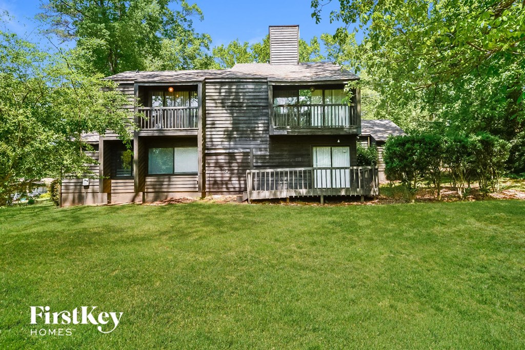 a house with a lawn and trees in front of it