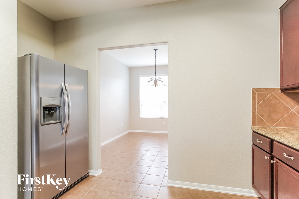 an empty kitchen with a stainless steel refrigerator