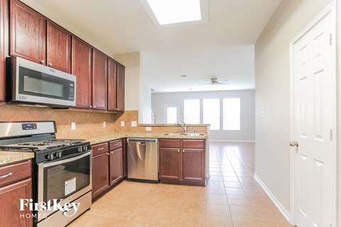 a kitchen with wooden cabinets and a stove and a microwave