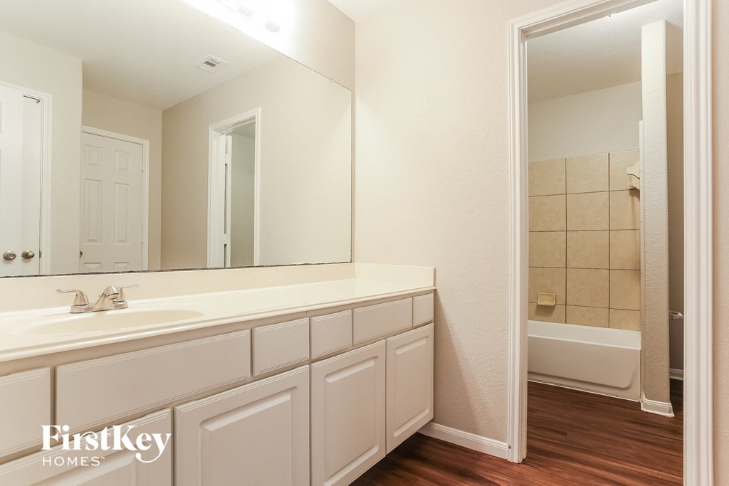 a bathroom with a large mirror and a white sink