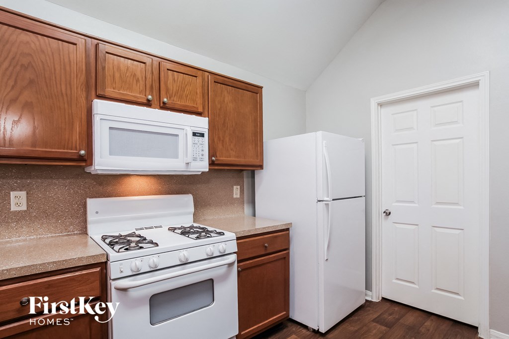 A kitchen with wooden cabinets and a white refrigerator.