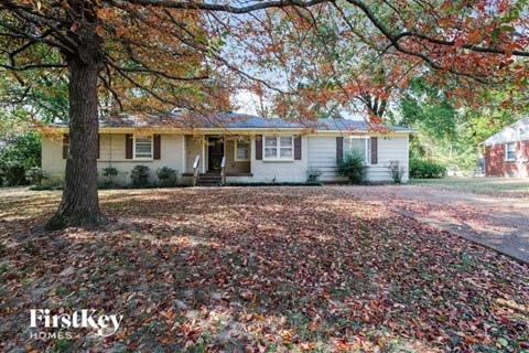 a white house with a large tree in front of it