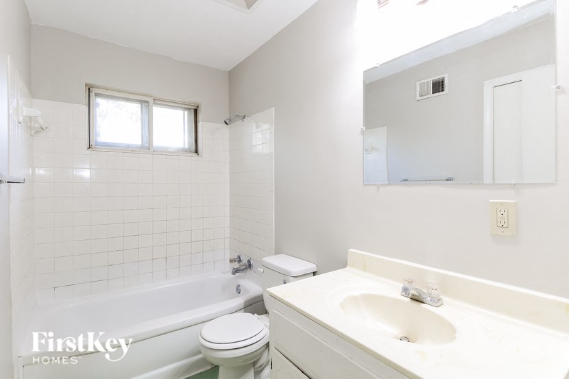 a white bathroom with a sink toilet and bath tub