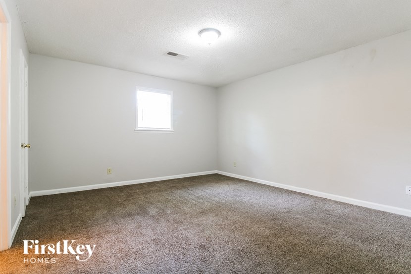 an empty room with carpet and a window