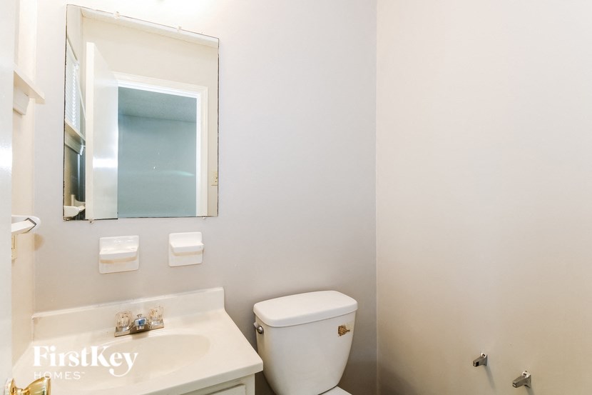 a bathroom with a toilet and a sink and a mirror