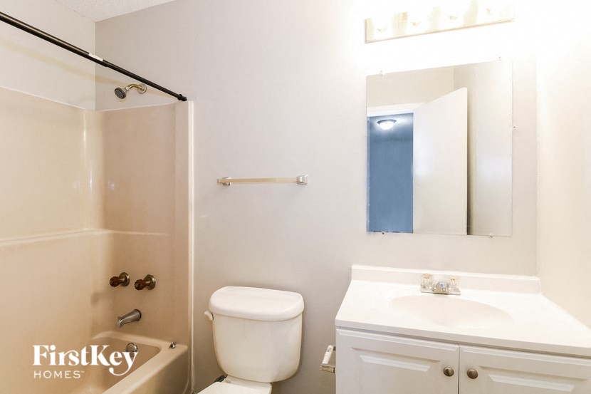 a bathroom with a sink toilet and a mirror