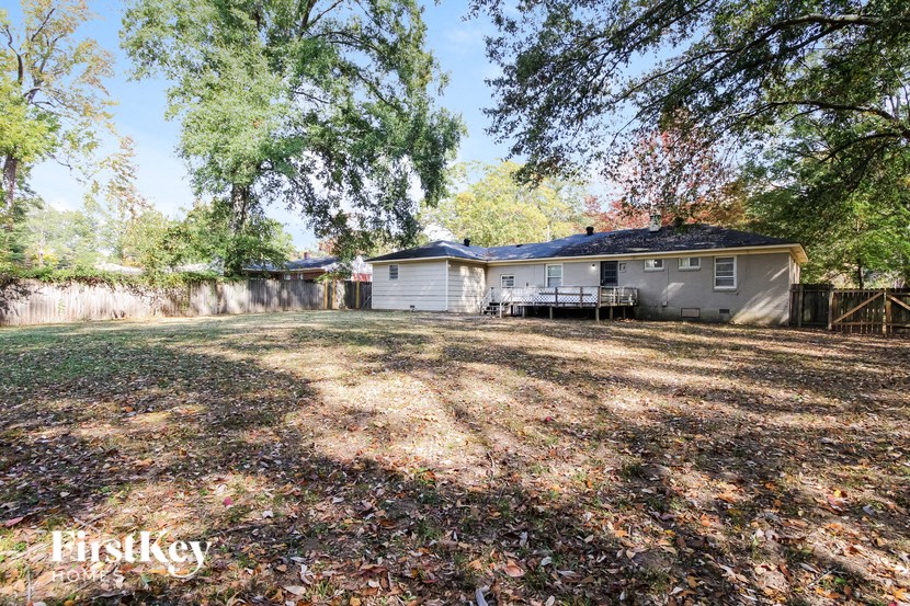 a backyard with a house and a yard with trees