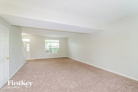 A room with a carpeted floor and a door on the left side.