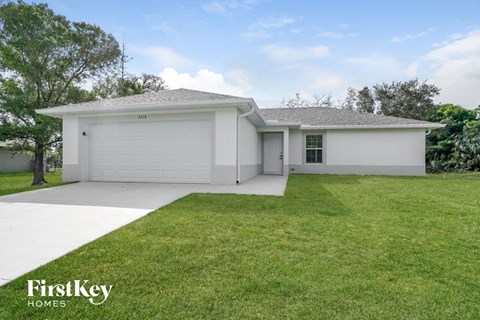 a white house with a lawn and a garage door
