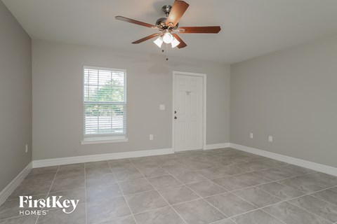 an empty room with a ceiling fan and a door