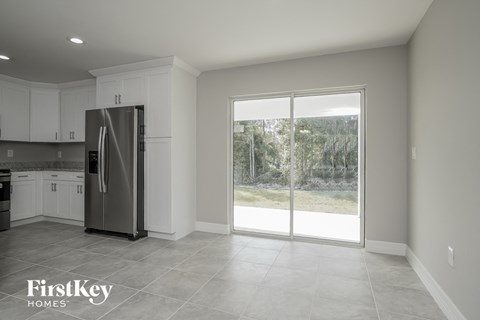 a kitchen with a stainless steel refrigerator and white cabinets