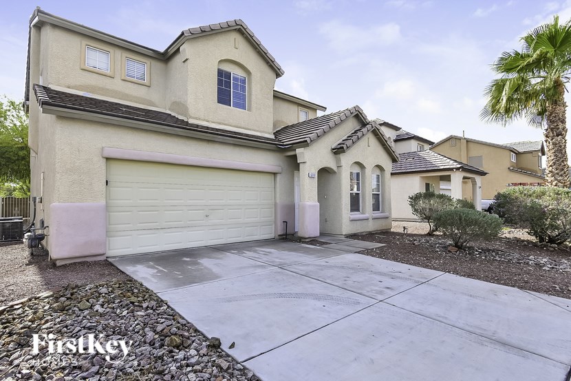 A house with a garage and a palm tree in front.