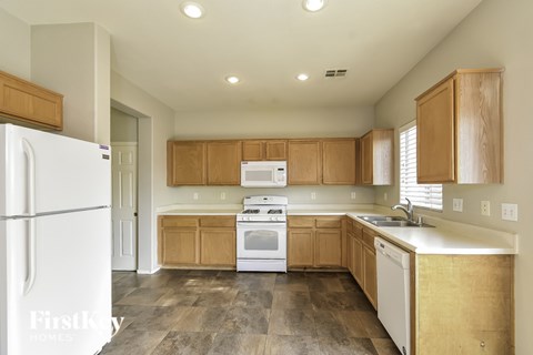 A kitchen with wooden cabinets and white appliances.