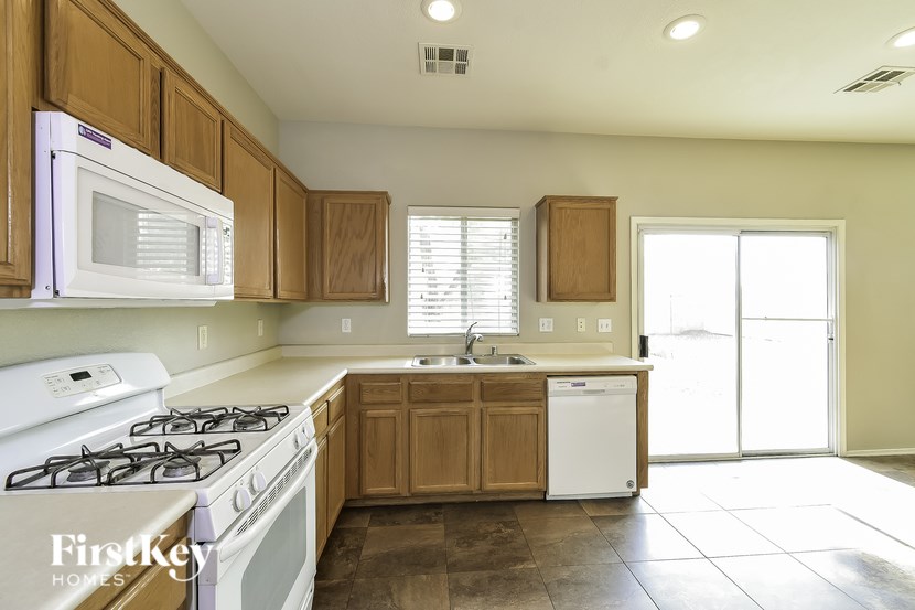 A kitchen with a white stove top oven and a white dishwasher.