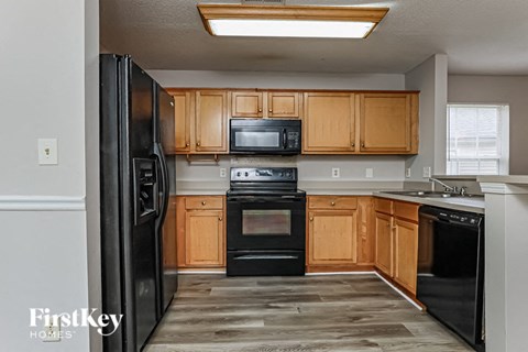 A kitchen with wooden cabinets and black appliances.