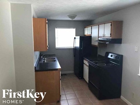 A kitchen with black appliances and wooden cabinets.
