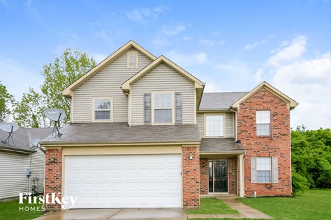 a home with a white garage door and a brick house