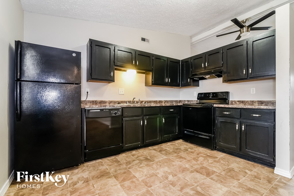 A kitchen with black appliances and cabinets.