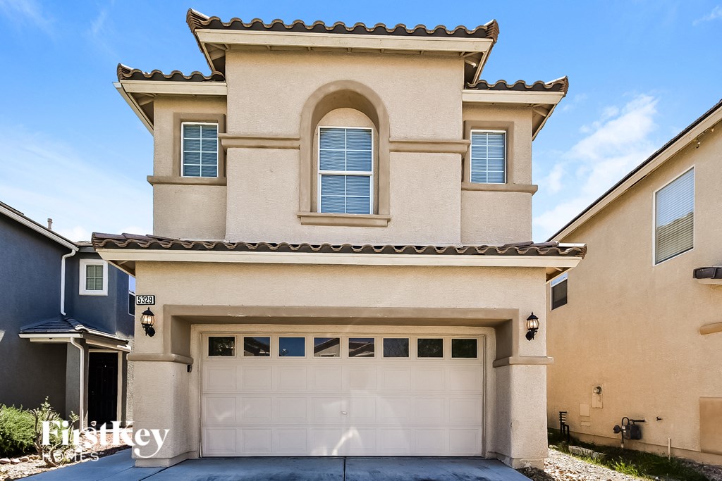 a tan house with a white garage door