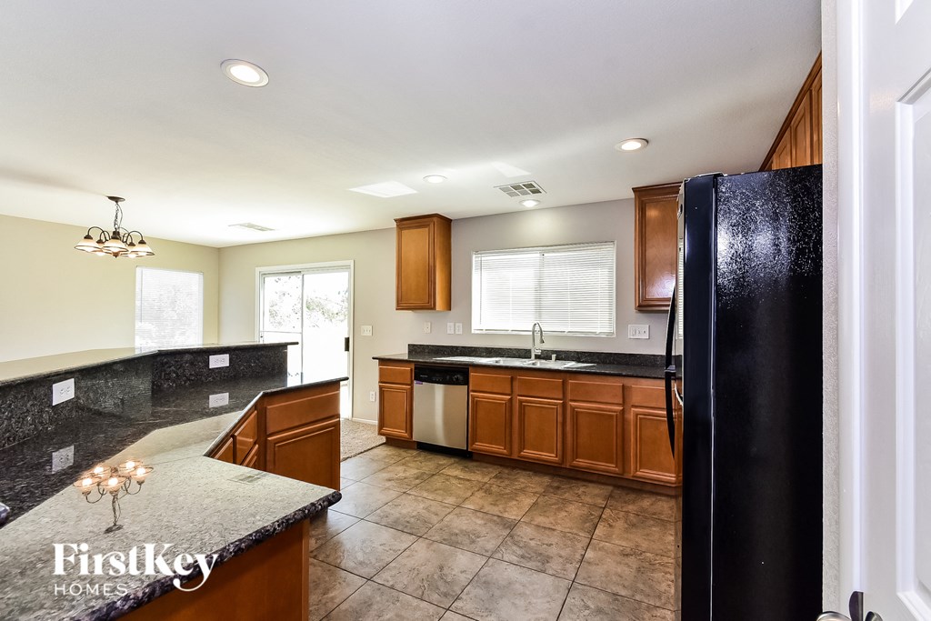 a kitchen with wooden cabinets and black appliances and a black refrigerator