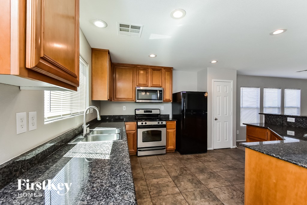a kitchen with granite counter tops and wooden cabinets