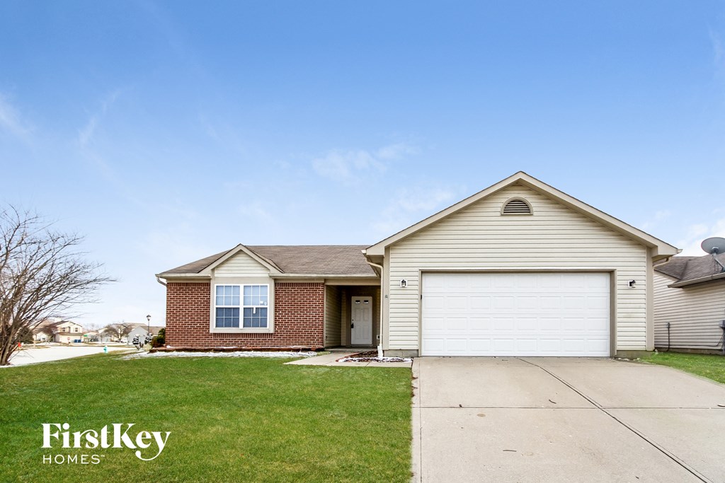 a white and brick house with a white garage door