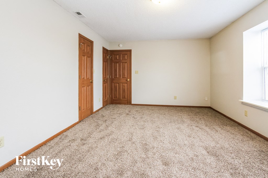 a bedroom with a carpeted floor and two doors