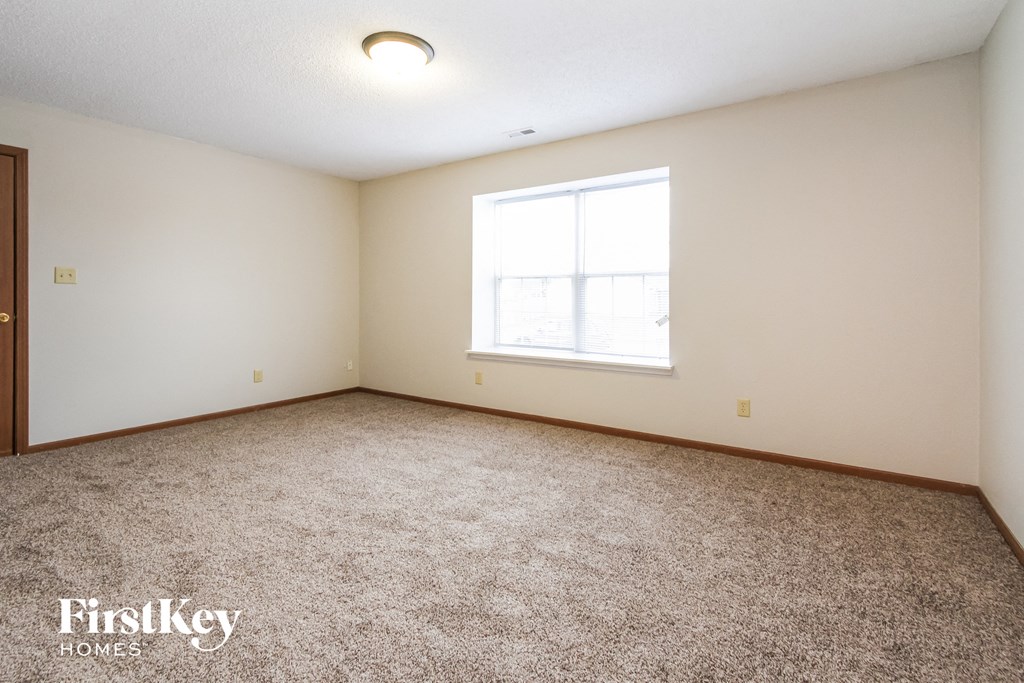 a bedroom with carpeted flooring and a window