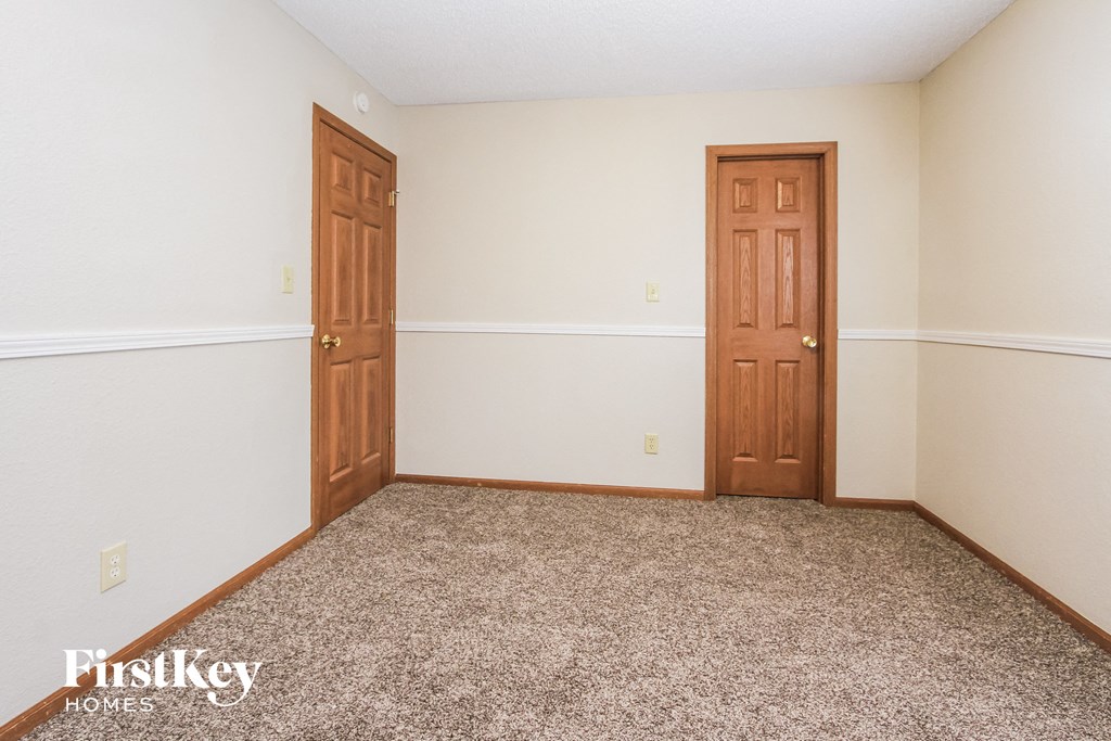 a bedroom with two doors and a carpeted floor
