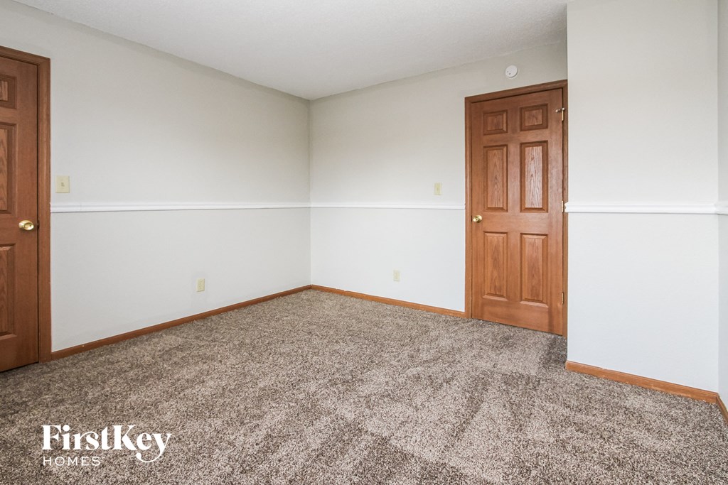 an empty room with a door and a carpeted floor
