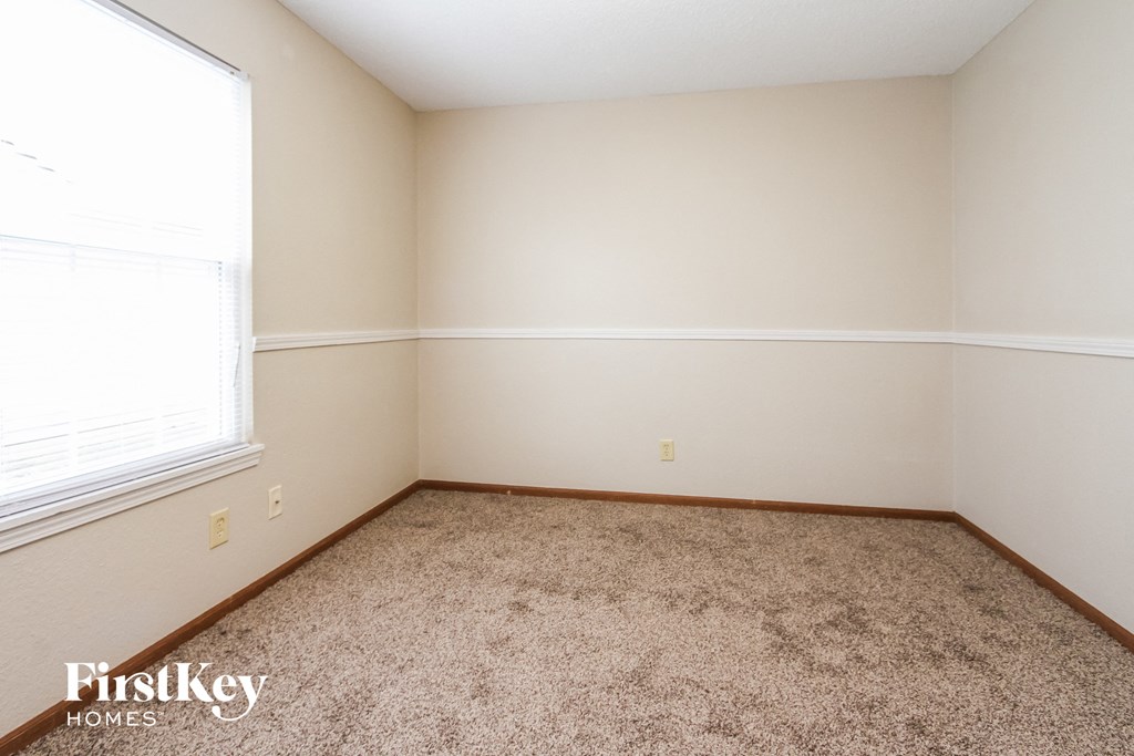 a bedroom with carpet and a large window