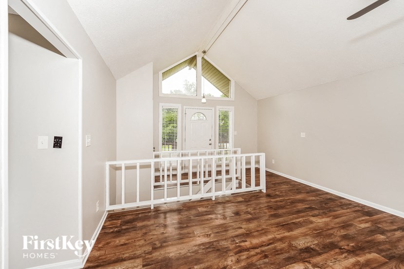 a room with a crib in front of a white door and a window