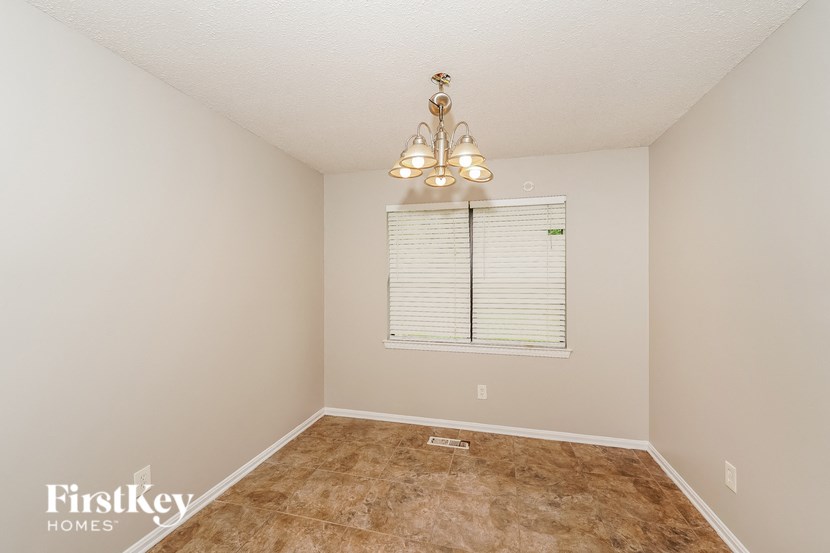 an empty room with a window and a chandelier