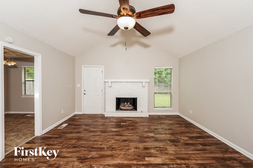 a living room with a fireplace and a ceiling fan