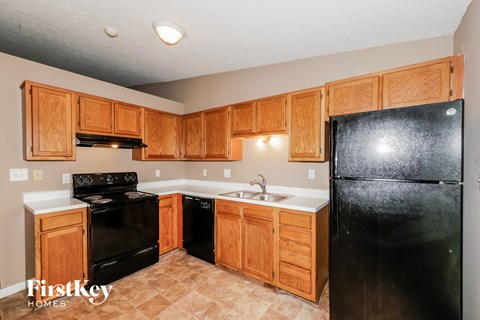 A kitchen with wooden cabinets and black appliances.