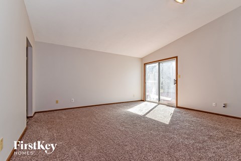 the living room with carpet and sliding glass door to the patio