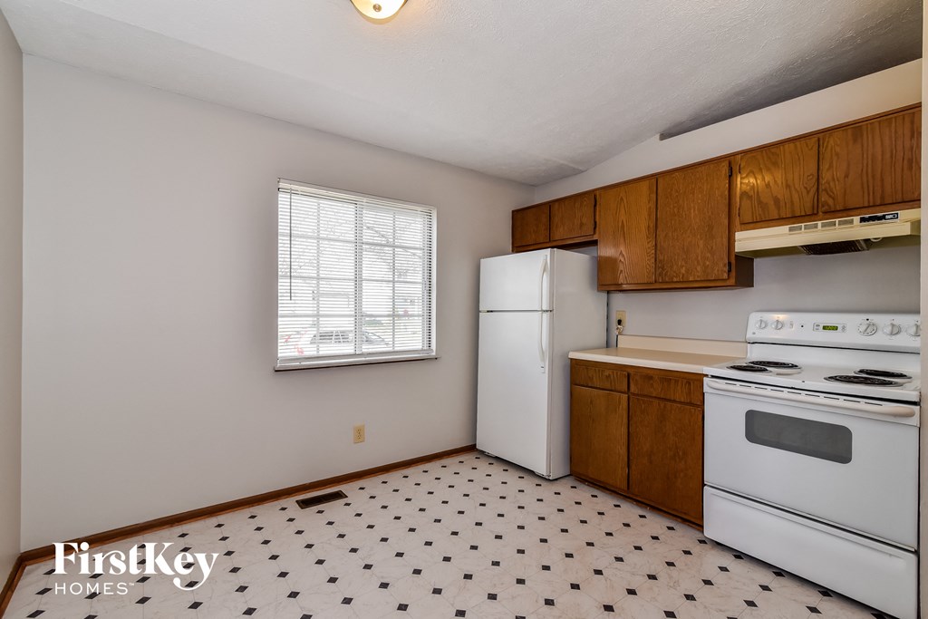 a kitchen with white appliances and wooden cabinets