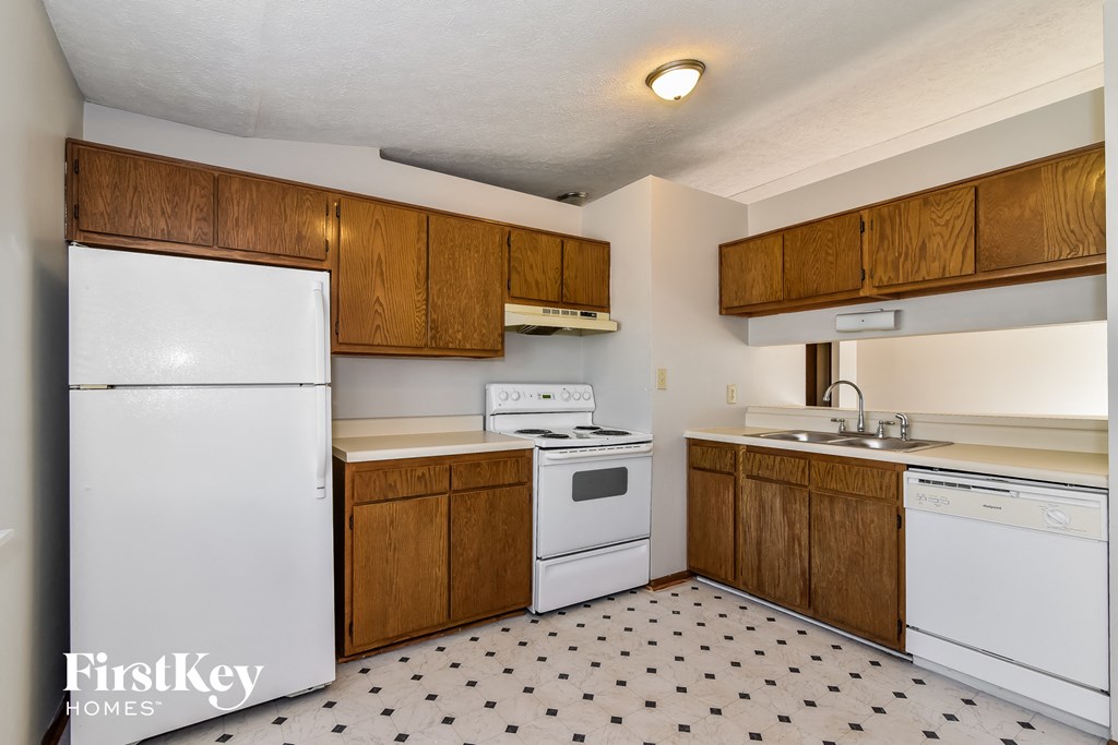 a kitchen with white appliances and wooden cabinets