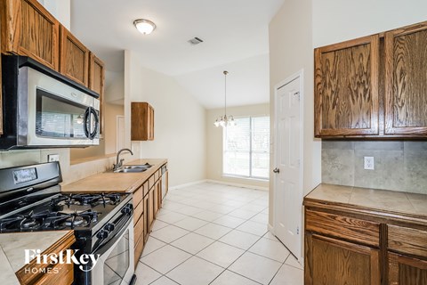 A kitchen with wooden cabinets and a stove top oven.