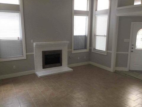 a living room with a fireplace and a tiled floor