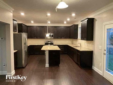 A kitchen with dark wood cabinets and a white island.