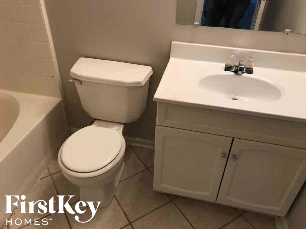 a white bathroom with a toilet and a sink