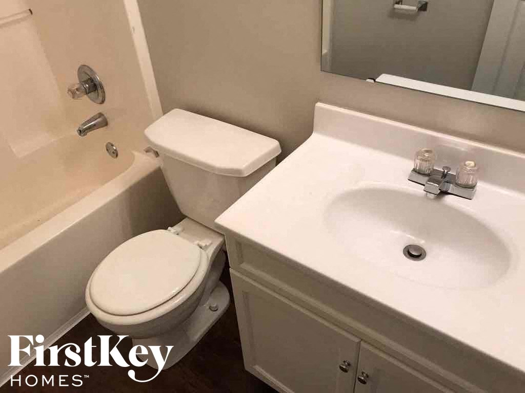 a bathroom with a toilet and a sink and a tub