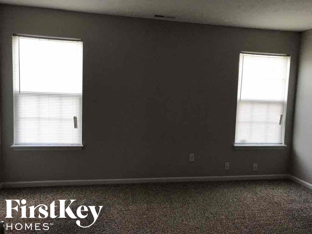 an empty room with two windows in it