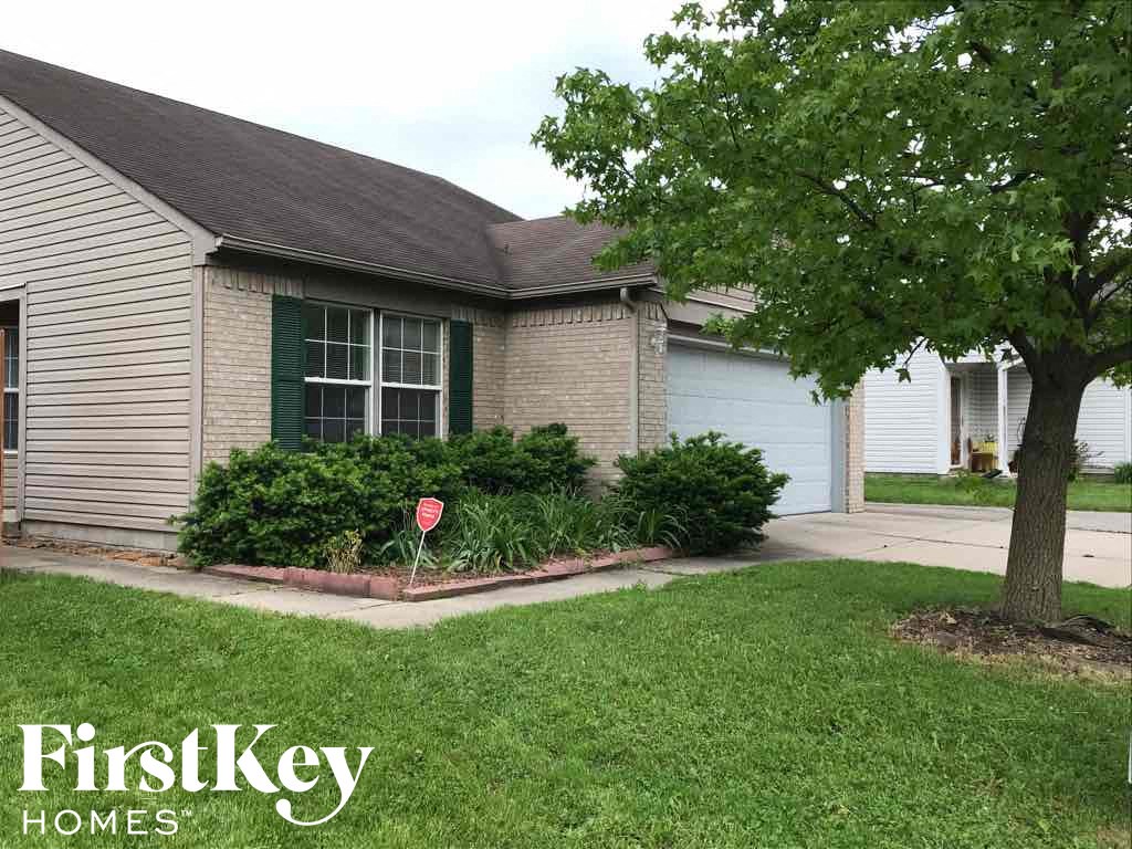 a yard with a stop sign in front of a house