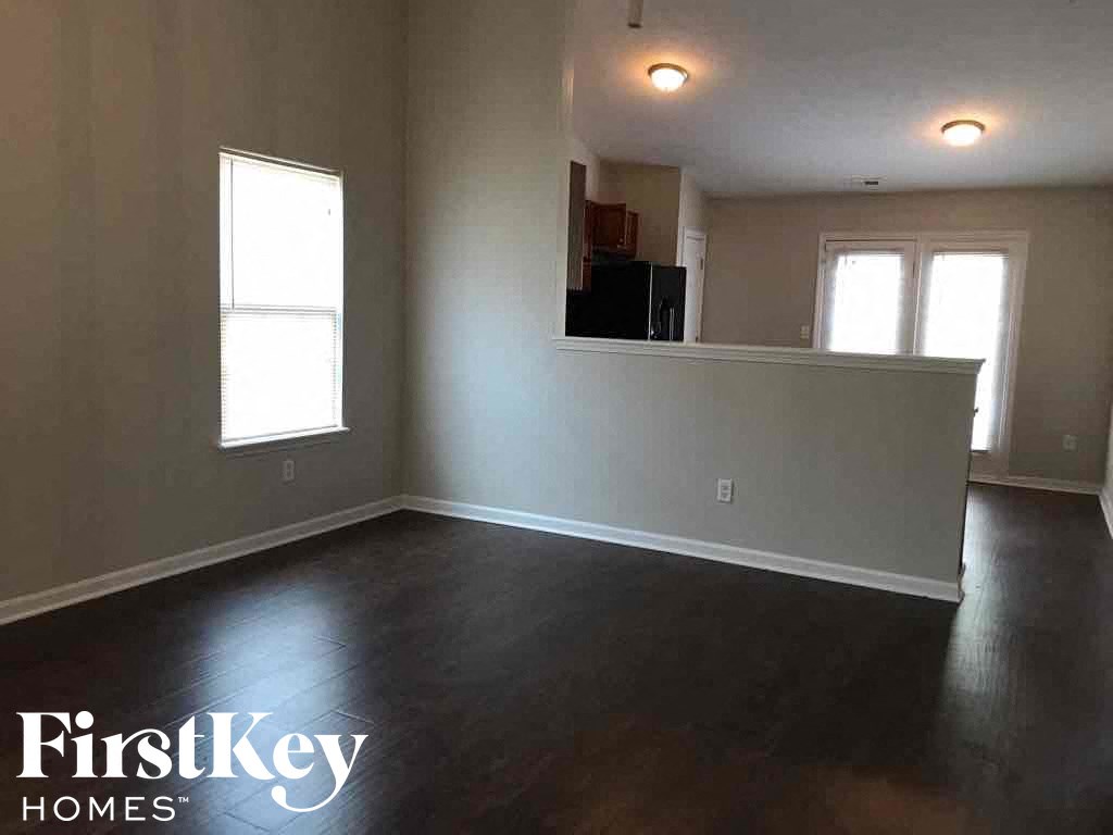 an empty living room with white walls and a hard wood floor